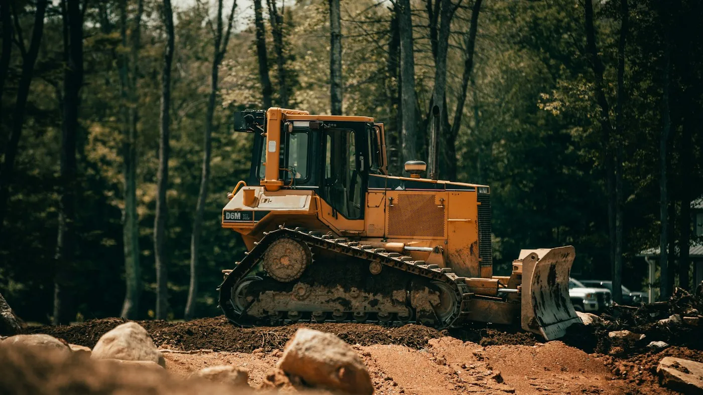 Bulldozer working beside a wooded site